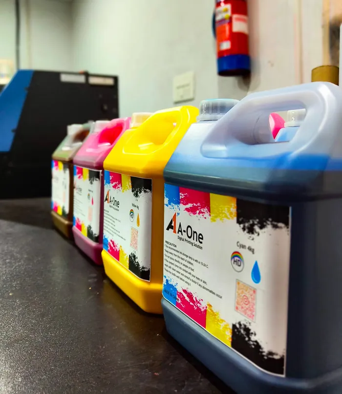 A-One ink canisters beside a textile printing machine