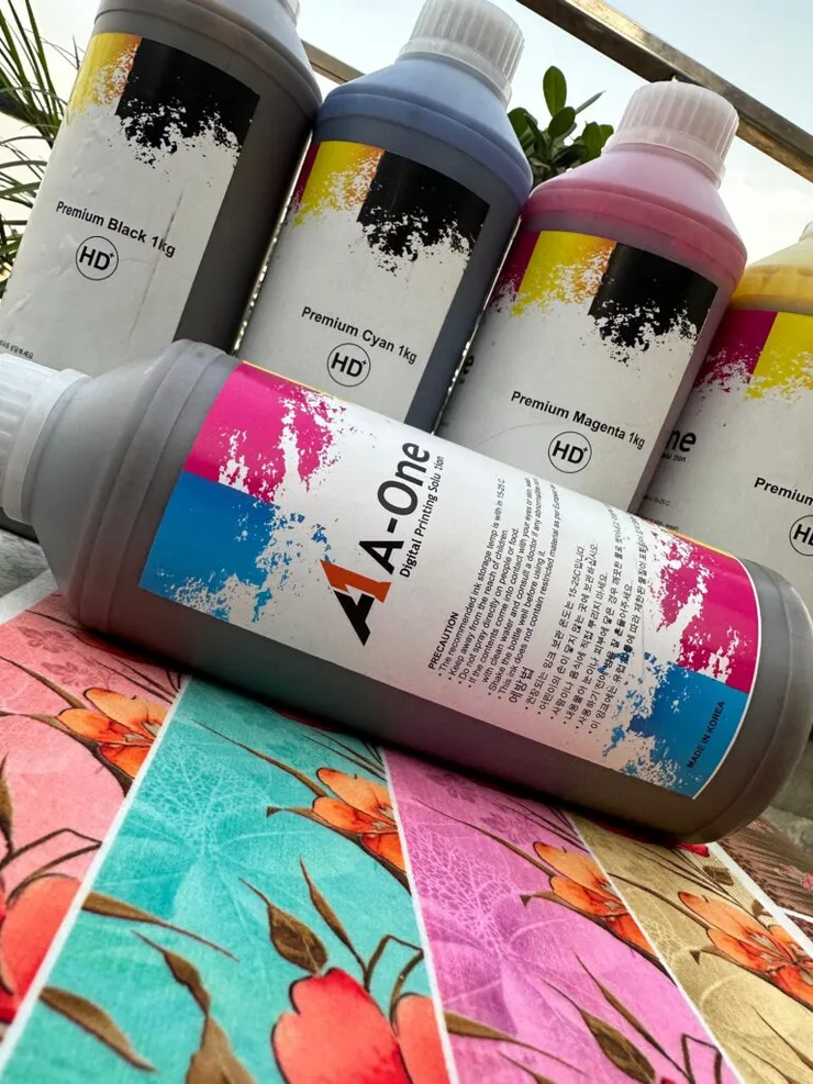 A-One sublimation ink bottles beside colourful printed samples